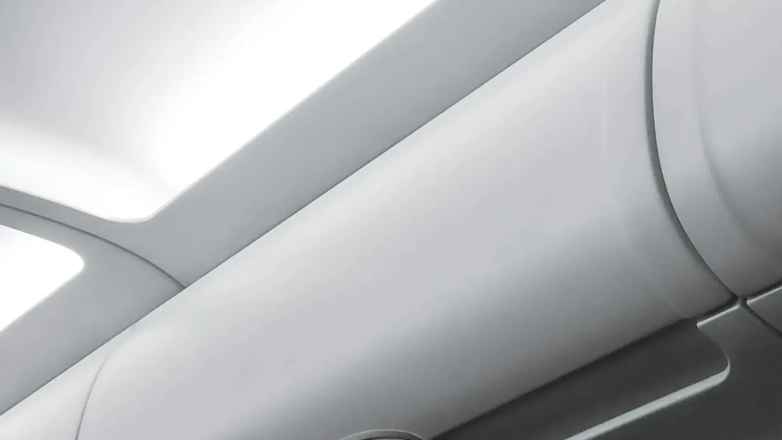 A close view of the curved white panels of an aircraft cabin interior