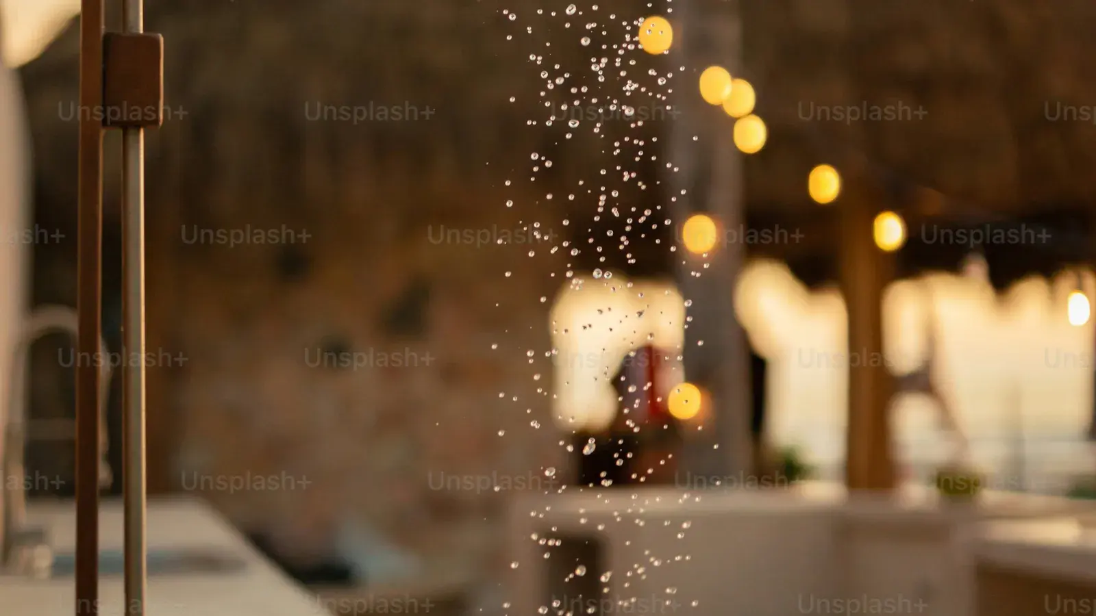 Water droplets on glass with warm out-of-focus lights behind them