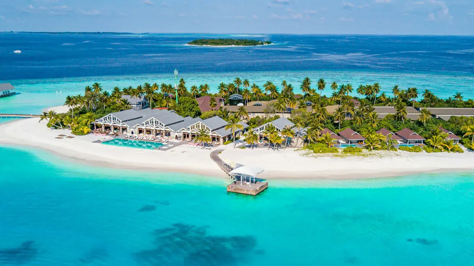An aerial view of a resort island ringed by reef and open ocean