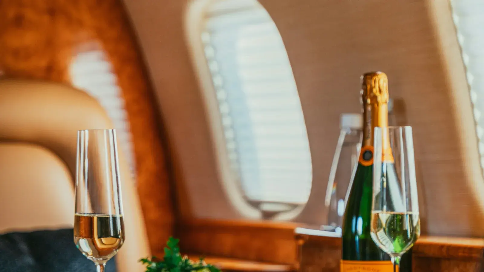 A bottle of champagne and two glasses on a business jet's table
