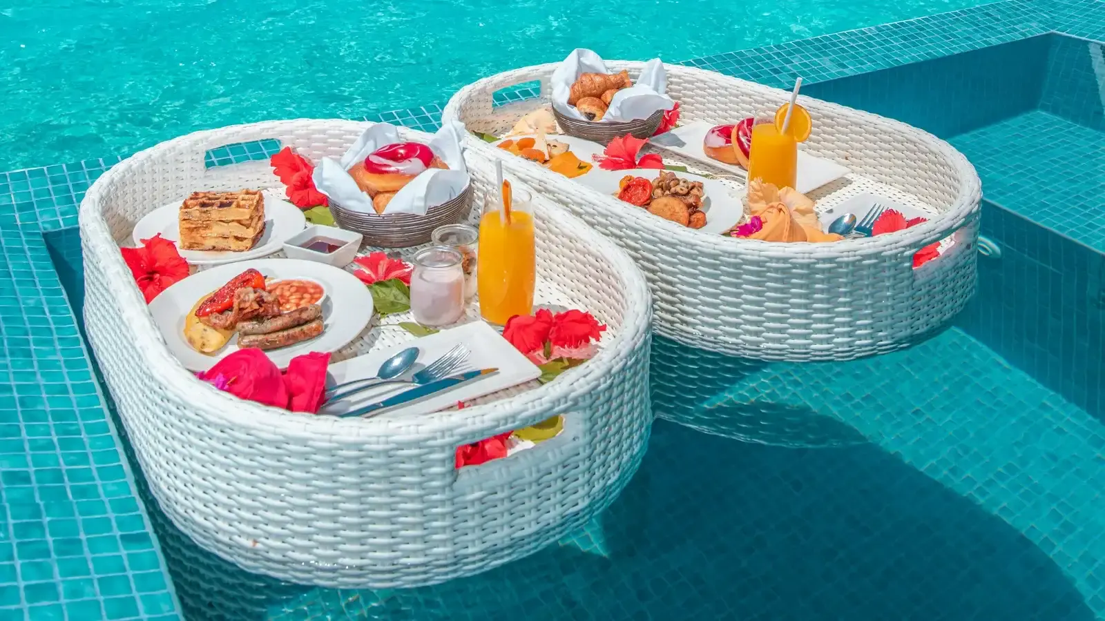 Breakfast trays floating on the water of a private villa pool